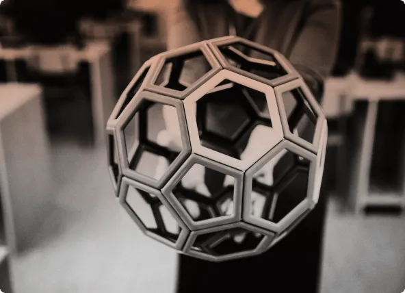 A hand holding an open geometric lattice ball